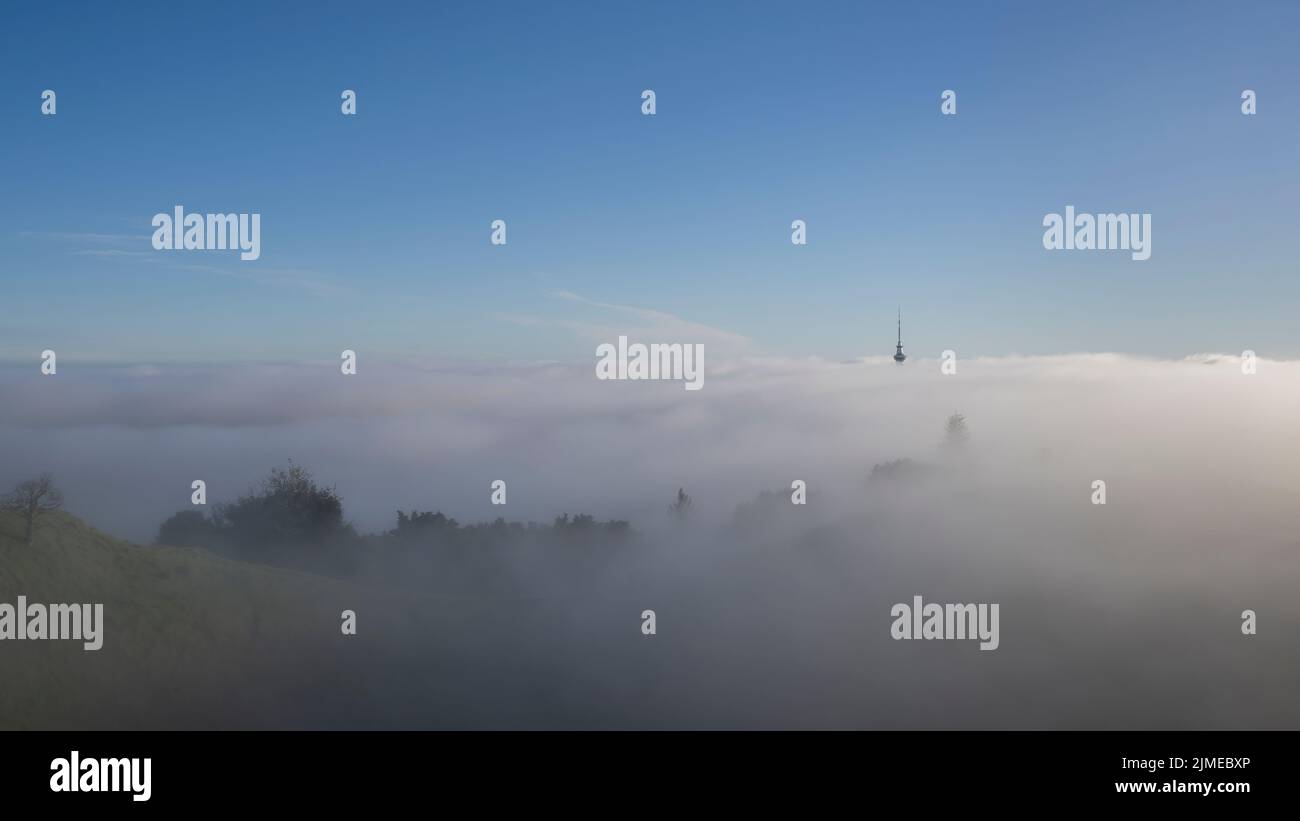 Auckland Sky Tower im Nebelmeer, vom Gipfel des Mount Eden. Vertikales Format. Stockfoto