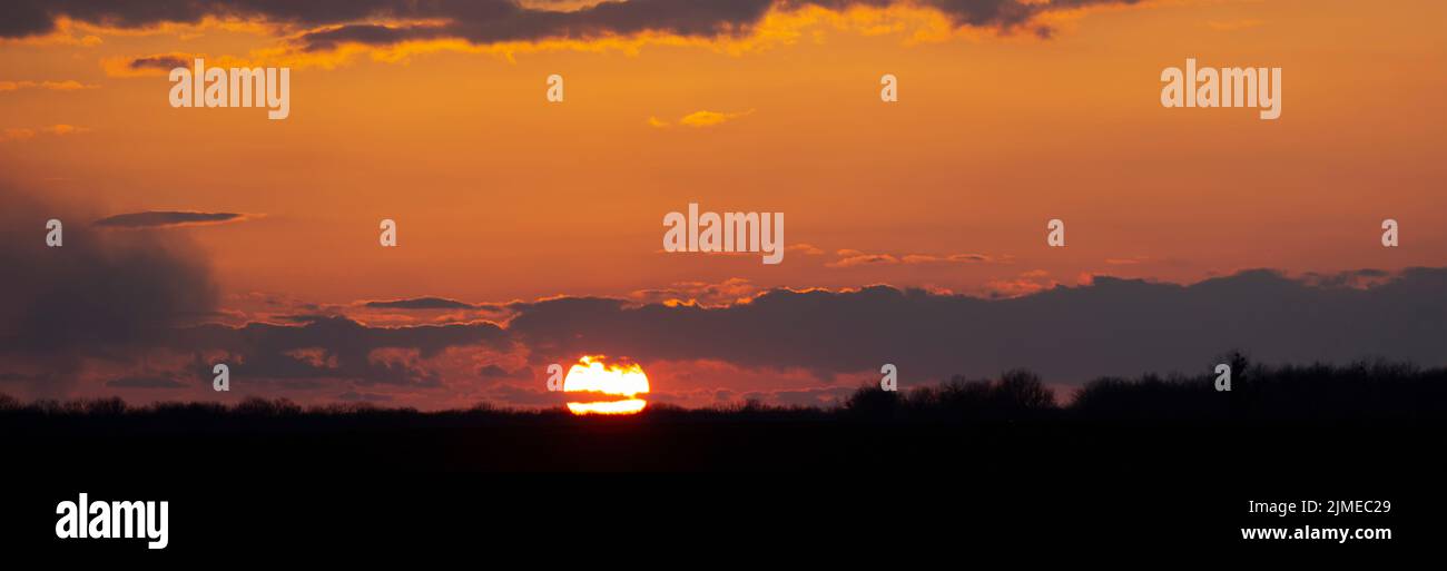 Panorama des Sonnenuntergangs am Horizont und des roten Himmels mit Wolken Stockfoto