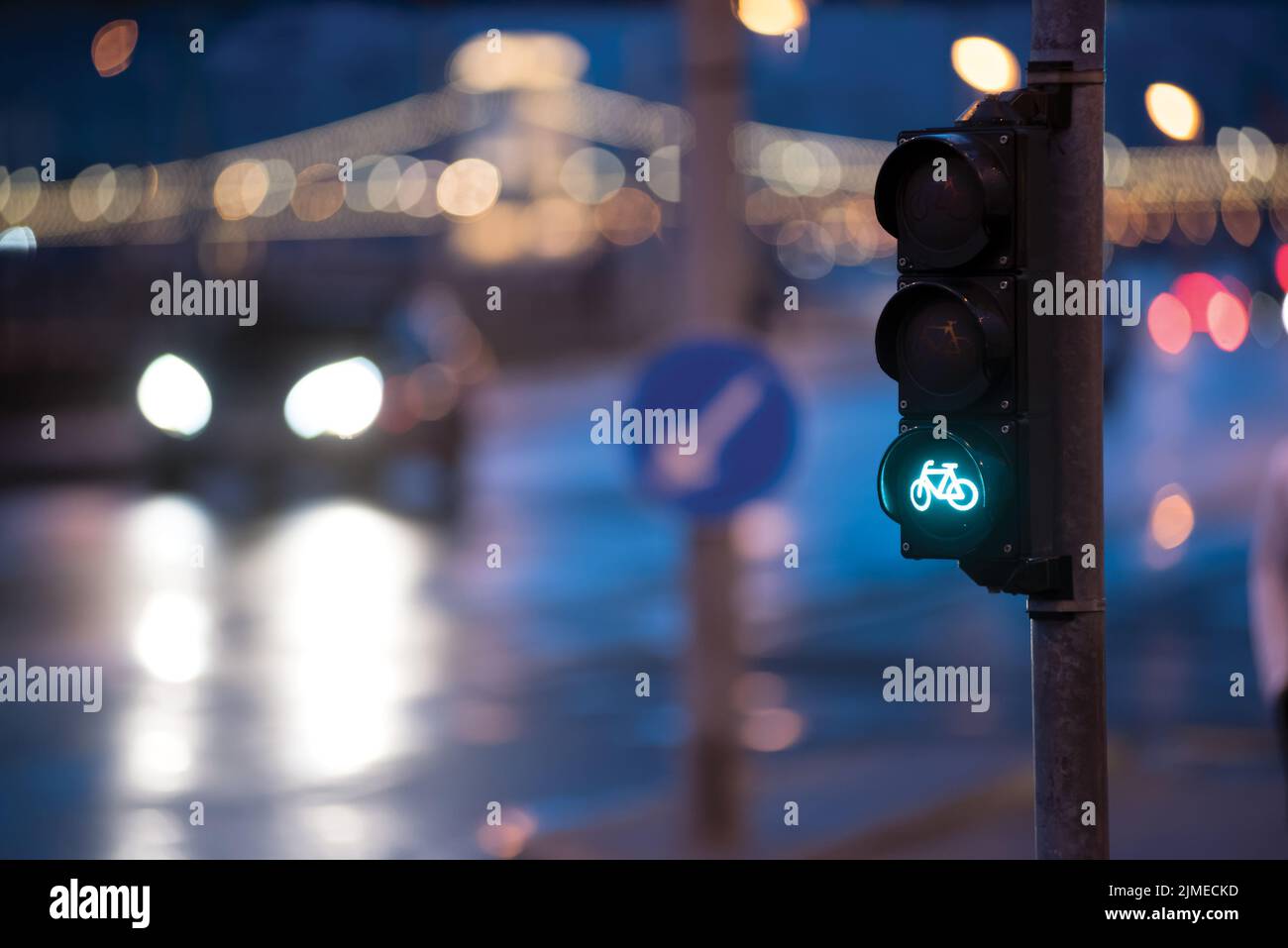 Fahrrad grüne Ampel gegen Stadtstraße in der Nacht Stockfoto