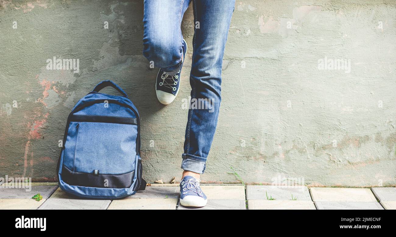 Schulmädchen Beine in blauen Jeans mit Rucksack zurück in die Schule Stockfoto