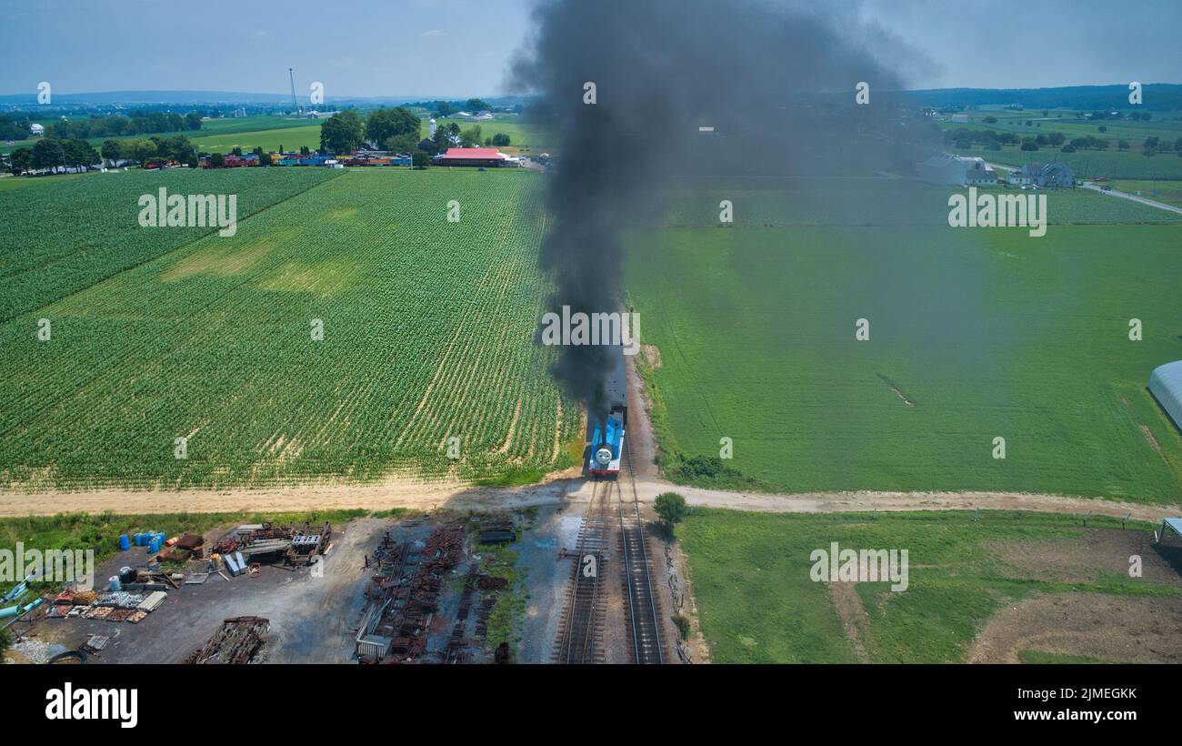 Luftkopf mit Blick auf Thomas, den Panzermotor, der sich durch Bäume und Ackerland nähert Stockfoto