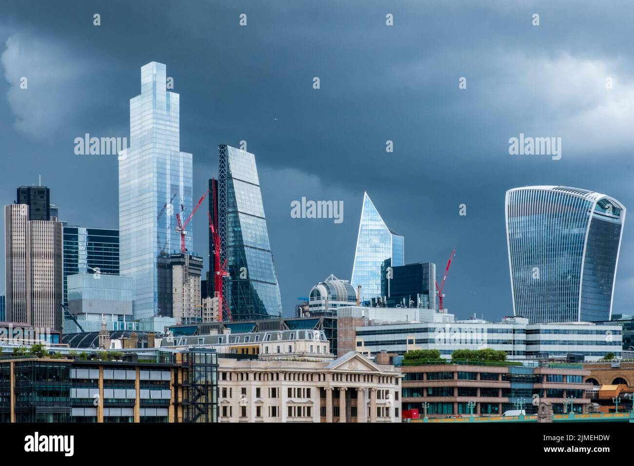 Geschäftsviertel der Stadt London glänzende Wolkenkratzer vor einem dramatischen, stürmischen Himmel. Stockfoto