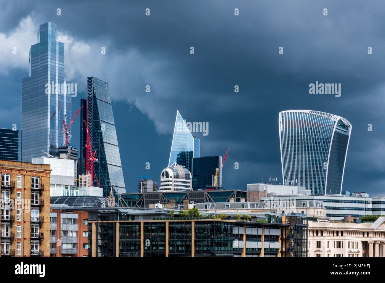Geschäftsviertel der Stadt London glänzende Wolkenkratzer vor einem dramatischen, stürmischen Himmel. Stockfoto