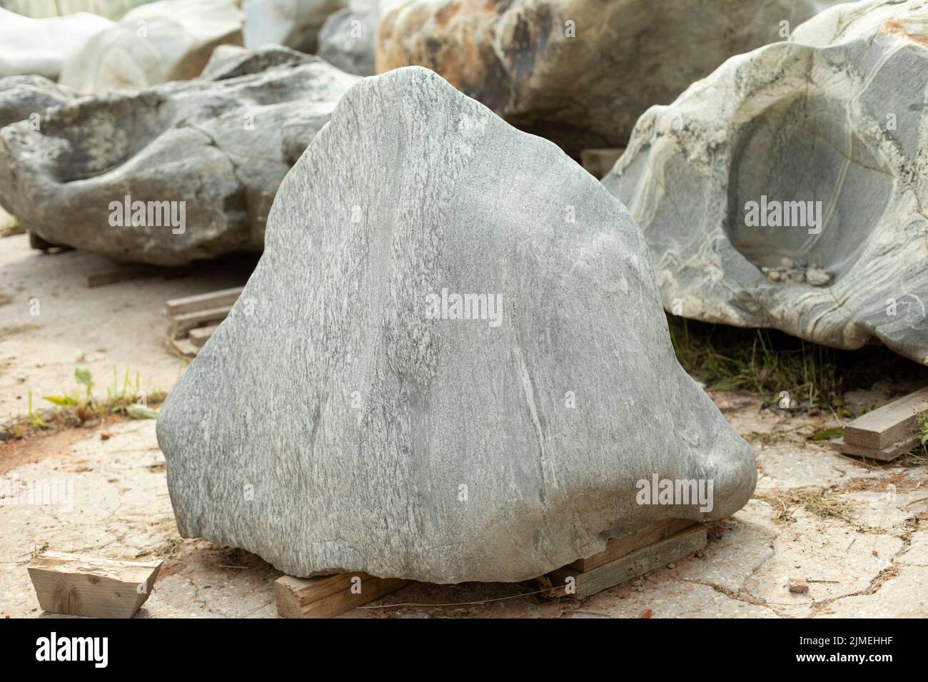 Schöner Stein, um den Park zu schmücken. Das Gestein ist für die Installation vorbereitet. Ein großer Felsblock von interessanter Form. Stockfoto