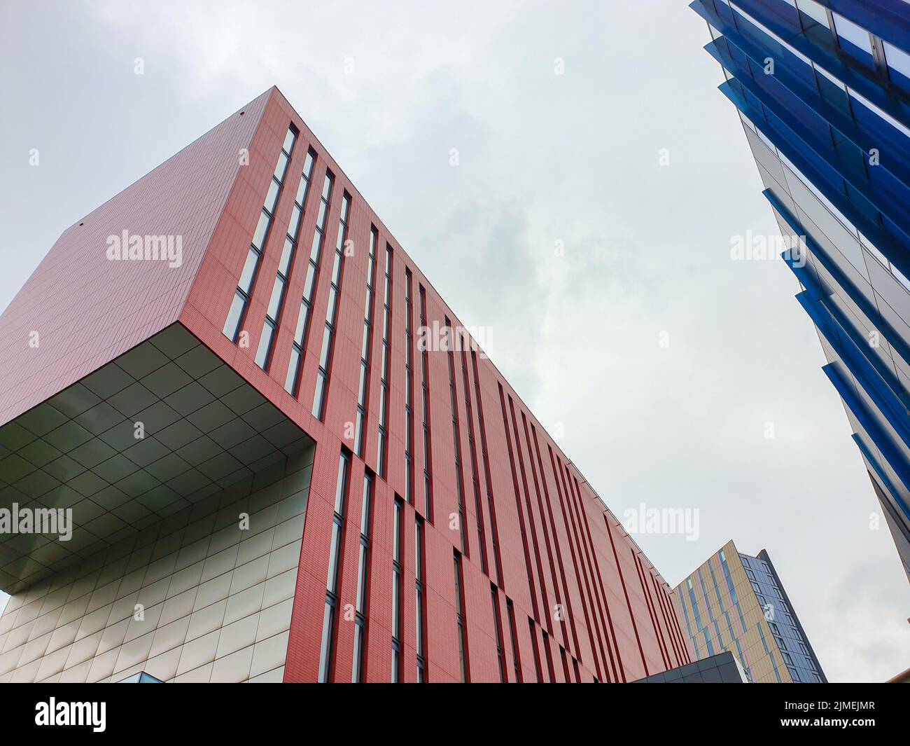 Kontrastierende Farben und Formen an Gebäudefassaden gegen den Himmel in Manchester, Großbritannien Stockfoto