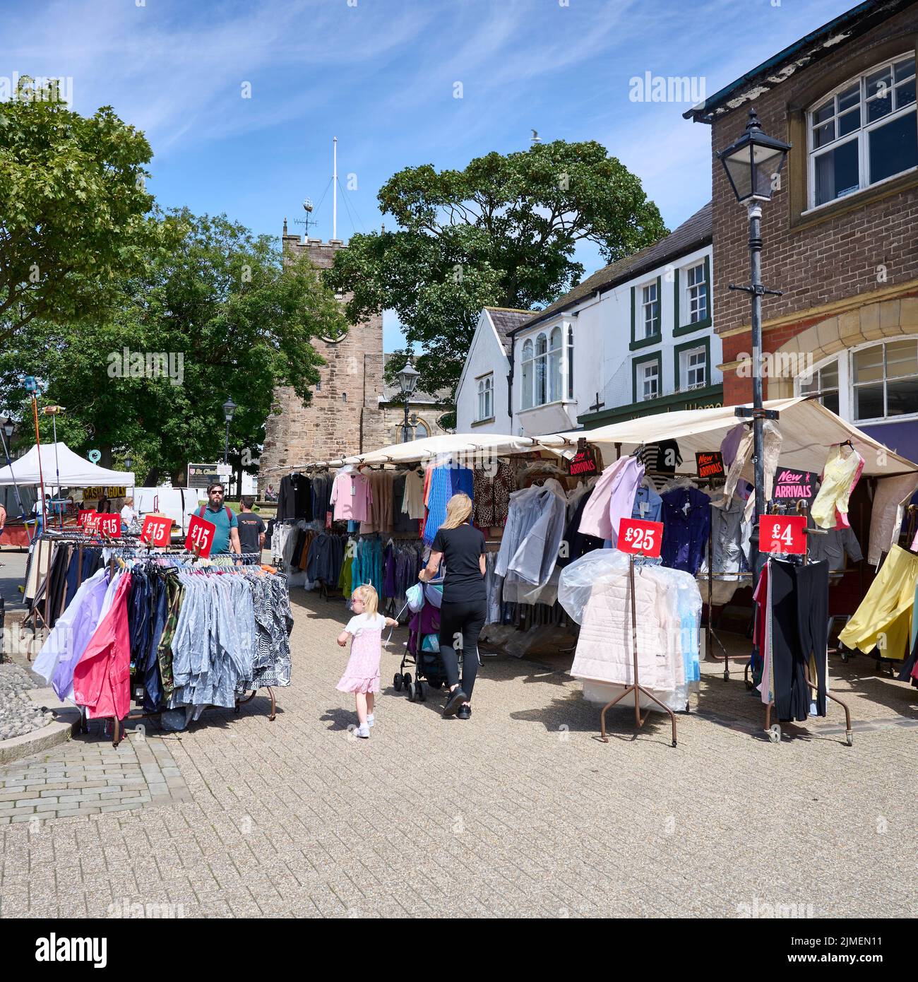 Frau und Kind gehen durch den wöchentlichen Markt im Freien, der auf dem Stadtplatz von Poulton-Le-fylde stattfindet Stockfoto