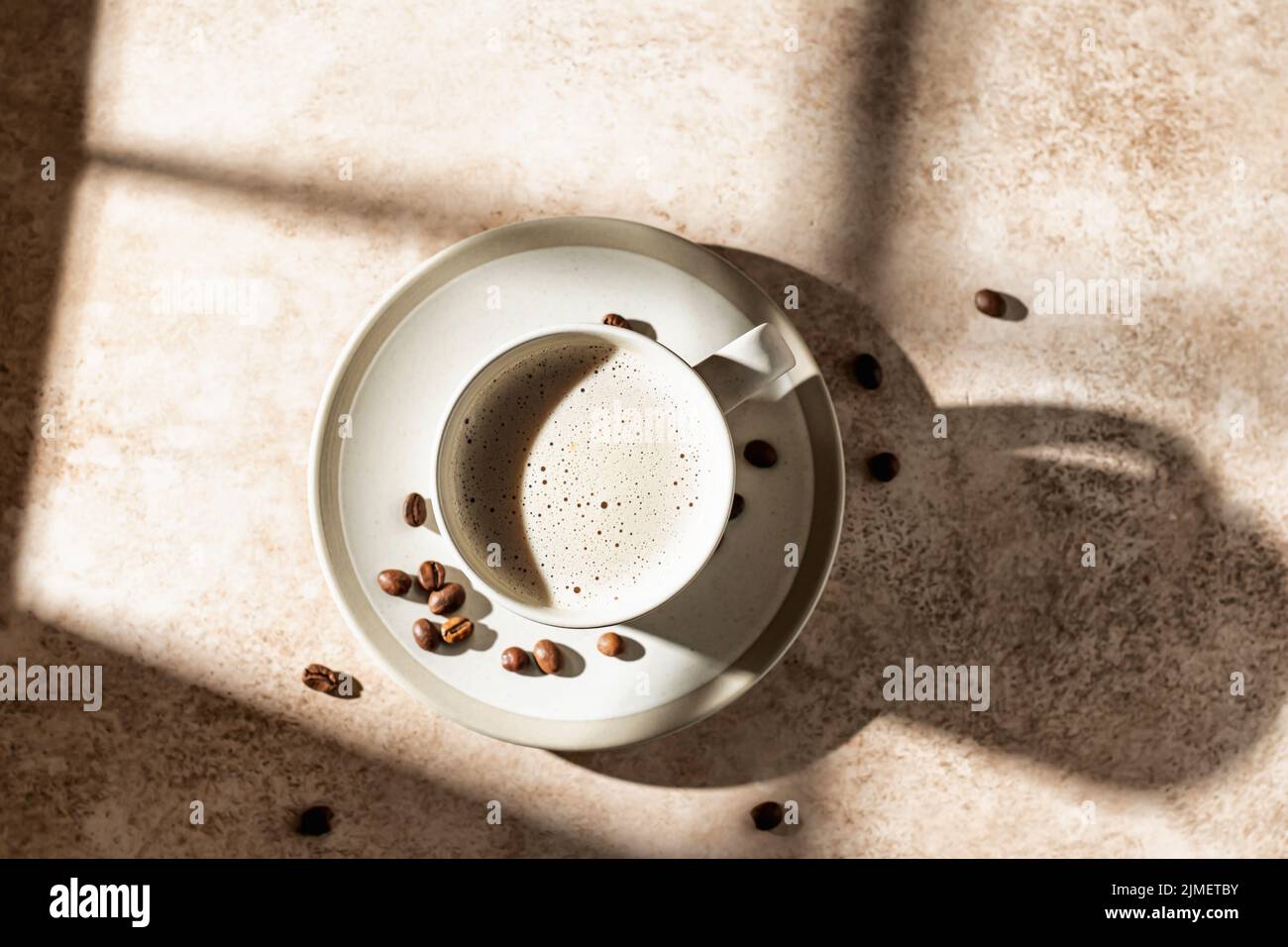 Cappuccino mit Schaumstoff bei hartem Licht mit schönen isolierten Schatten. Textbereich, Draufsicht Stockfoto