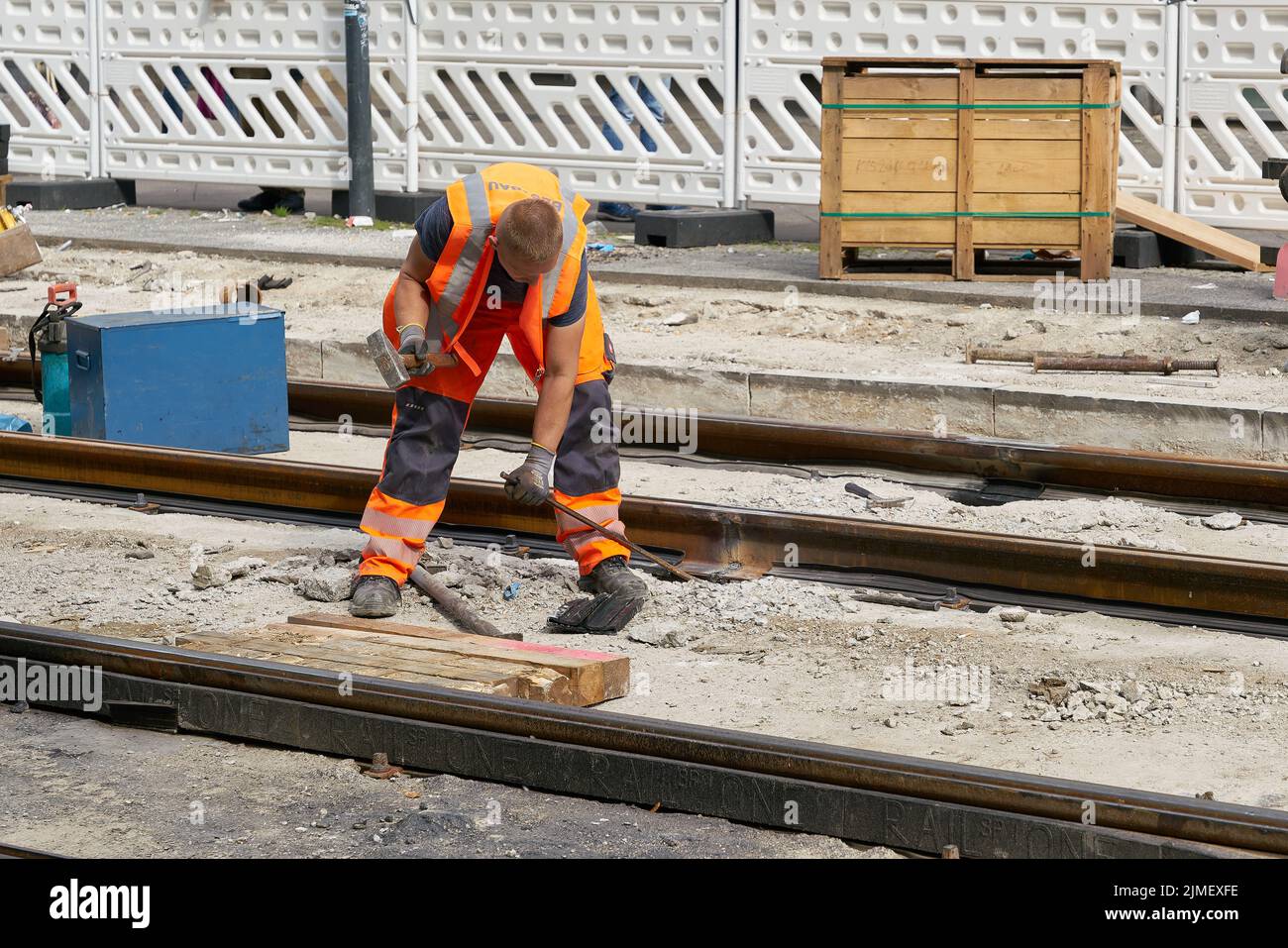 Ein Arbeiter, der die alten Spuren der Straßenbahn am Alexanderplatz in Berlin erneuert Stockfoto