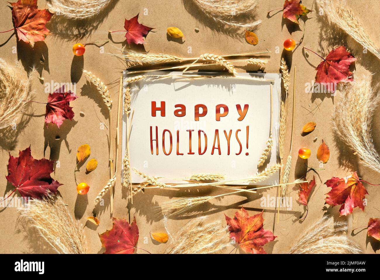 Herbstrahmen, Bildunterschrift Frohe Feiertage. Natürliche Herbstblätter, Weizenohren und Pampagras. Stockfoto