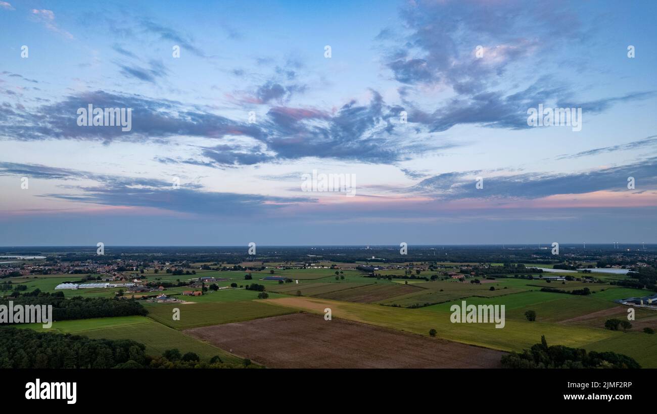 Luftaufnahme eines Abendhimmels über den Feldern, bedeckt mit Gewitterwolken, die beim Sonnenaufgang oder Sonnenuntergang eintreffen, aufgenommen mit Stockfoto