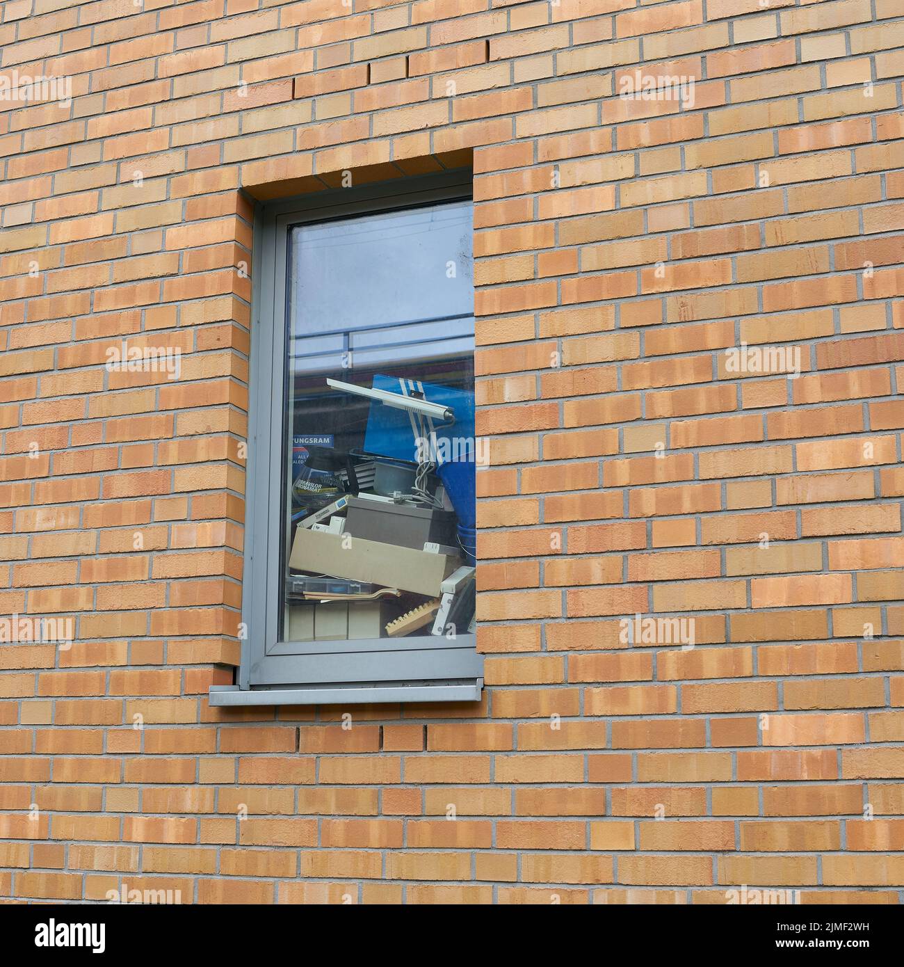 Unordentlich gestapelte Objekte am Fenster in einem Raum Stockfoto