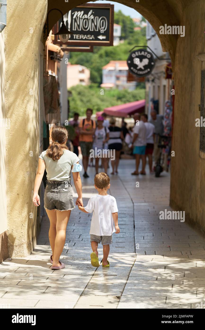 Urlauber in einer Gasse in der historischen Altstadt von Krk auf der gleichnamigen Insel in Kroatien Stockfoto