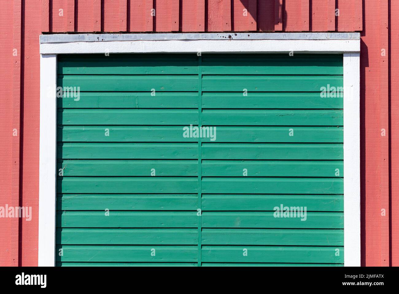 Eine grüne Holztür auf einem roten Gebäude in Littlehampton, West Sussex, Großbritannien Stockfoto