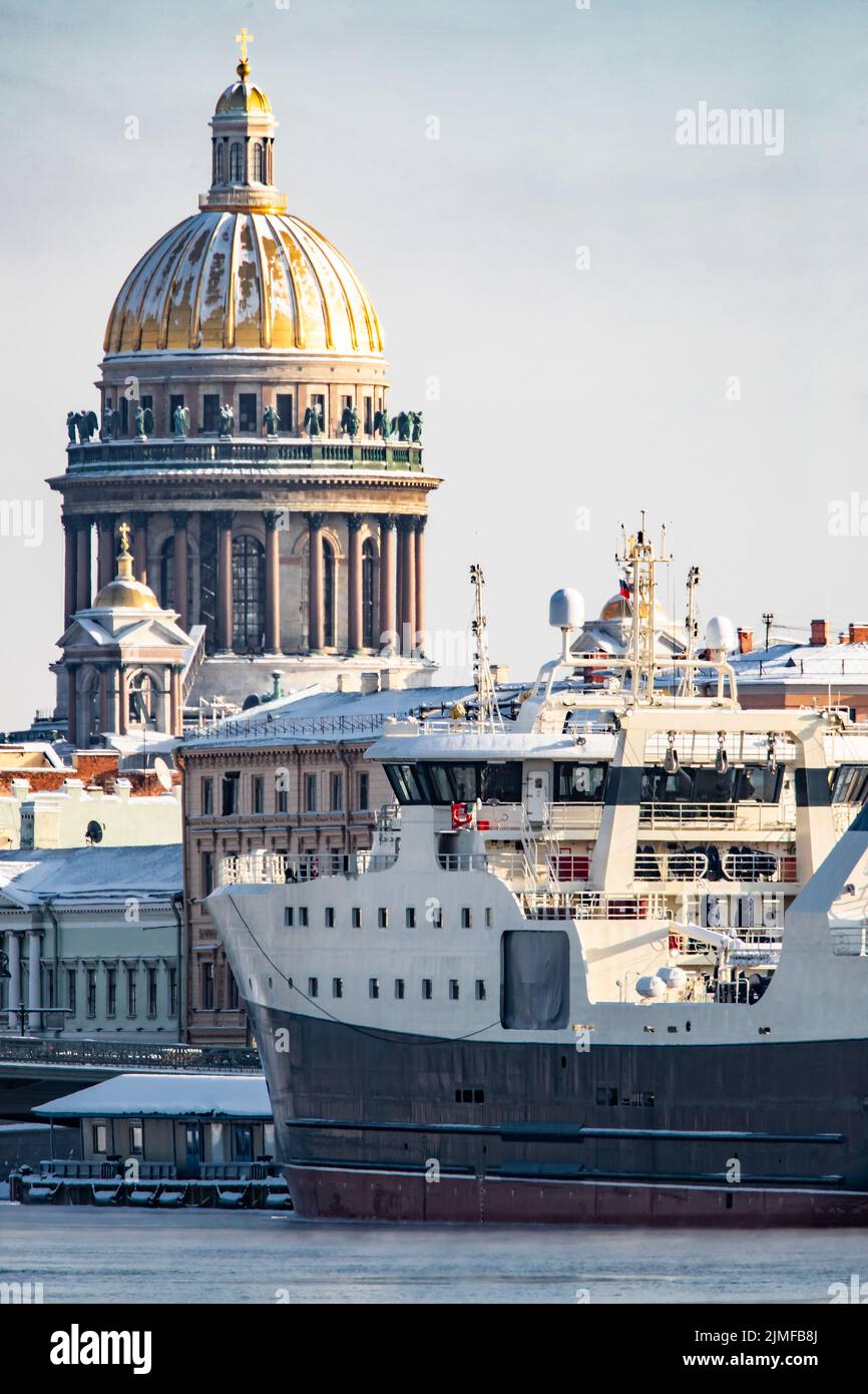 Der Panoramablick auf die Winterstadt Sankt-Petersburg, das große Schiff, das in der Nähe der Blagoweschtschenski Brücke festgemacht ist, die Isaakskathedrale auf dem Rückbau Stockfoto