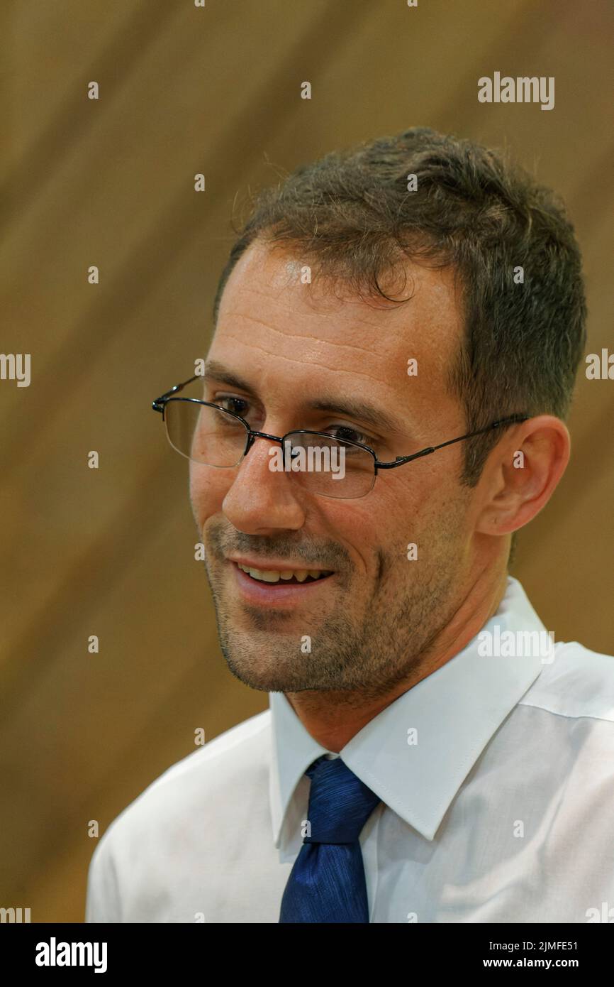 Calvert City, KY, USA. 05 August 2022. Drew Williams, Vorsitzender des Exekutivkomitees der Demokratischen Partei von Marshall County, lacht mit einem Teilnehmer am 25. Mike Miller Memorial Marshall County Bean Dinner im Kentucky Dam Village State Resort Park. Die Spendenaktion der Marshall County Democratic Party findet am Vorabend des jährlichen St. Jerome Fancy Farm Picnic statt, dem traditionellen Beginn der politischen Wahlkampfsaison in Kentucky. (Kredit: Billy Suratt/Apex MediaWire über Alamy Live News) Stockfoto