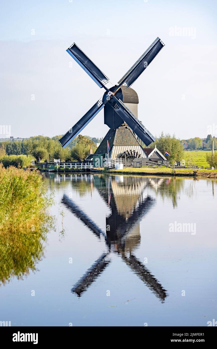 Vertikales Bild einer der berühmten niederländischen Windmühlen in Kinderdijk, einem UNESCO-Weltkulturerbe. Auf dem Foto ist der eine schwarz Stockfoto