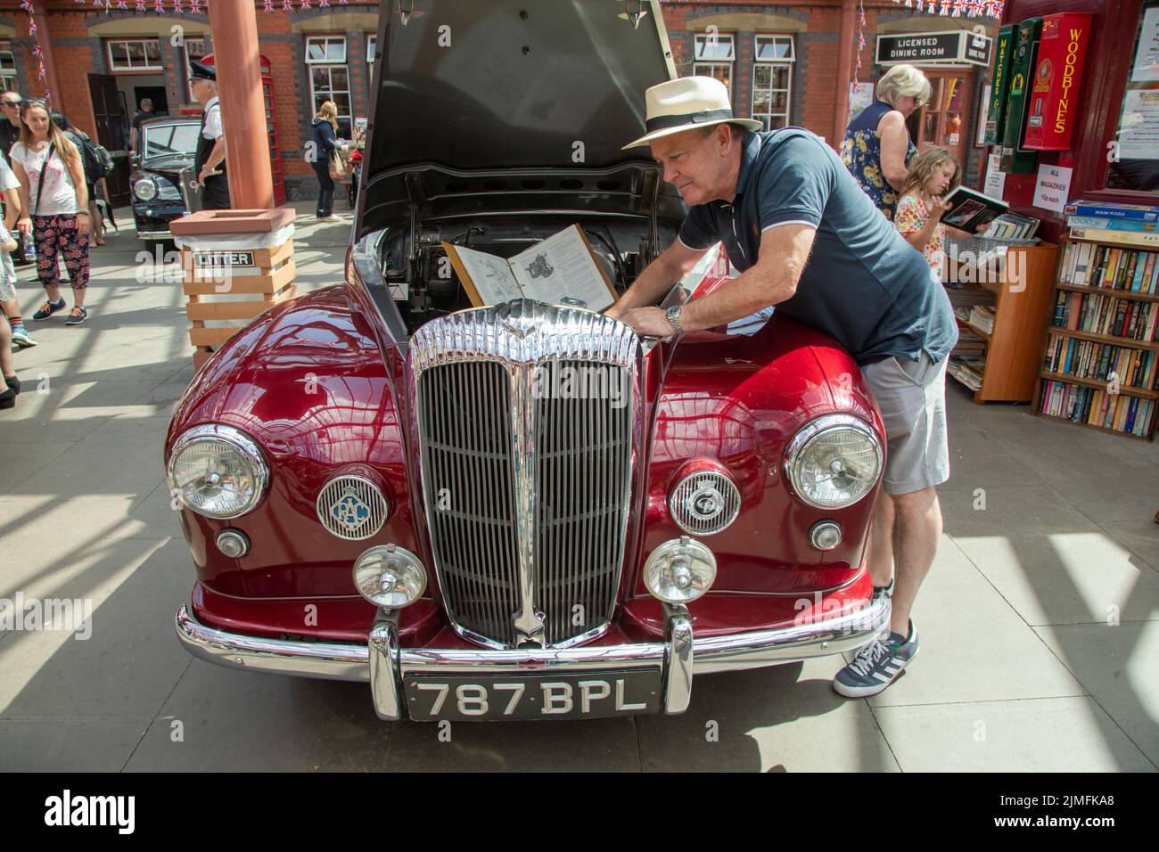 Kidderminster, Worcs, Großbritannien. 6. August 2022. Robert Back bezieht sich bei der Vorbereitung seines Daimler Conquest 1956, einem 10 Jahre andauernder Restaurierungsarbeit dauerndes Pride and Joy-Projekt, auf seine ursprüngliche Fahrzeuganleitung im Rahmen der Vintage Transport Extravaganza in Kidderminster, Worcestershire. Die jährliche Veranstaltung hat Dampfmaschinen sowie Oldtimer-Kraftfahrzeuge. Kredit: Peter Lopeman/Alamy Live Nachrichten Stockfoto