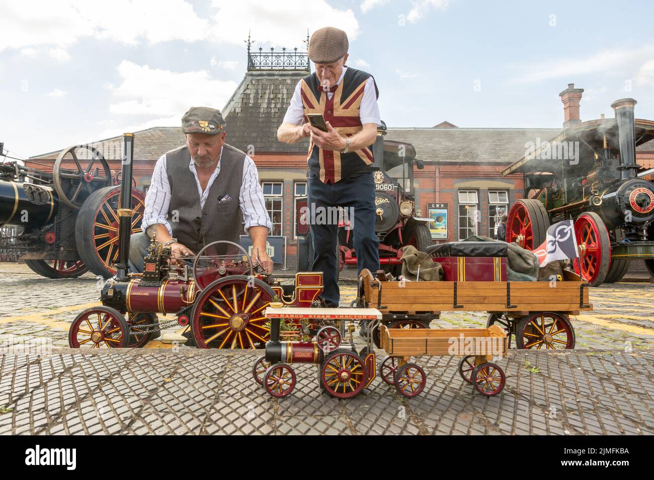 Kidderminster, Worcs, Großbritannien. 6. August 2022. Der Dampfenthusiast Michael Pryce zeigt mit Jim Parker seinen Stolz und seine Freude an der Miniatur-Dampflokomotive „Smokey Joe“ im Maßstab 1:1:3 in der Vintage Transport Extravaganza der Severn Valley Railway in Kidderminster, Worcestershire. Die jährliche Veranstaltung umfasst Oldtimer-Fahrzeuge sowie Dampfmaschinen. Kredit: Peter Lopeman/Alamy Live Nachrichten Stockfoto