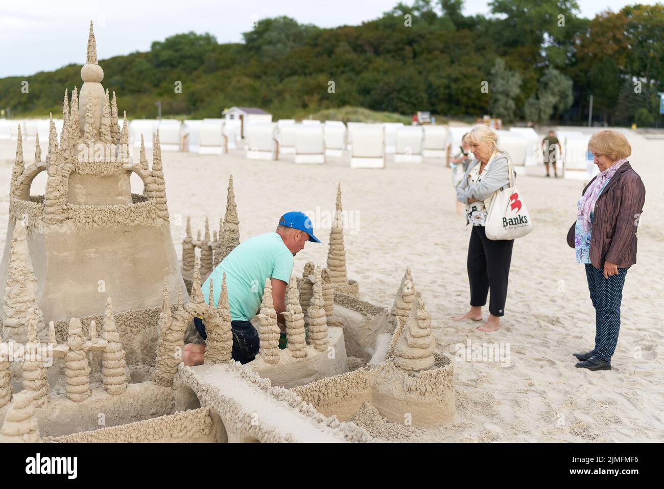 Urlauber bewundern eine Sandburg am Strand von Kolobrzeg an der polnischen Ostseeküste Stockfoto