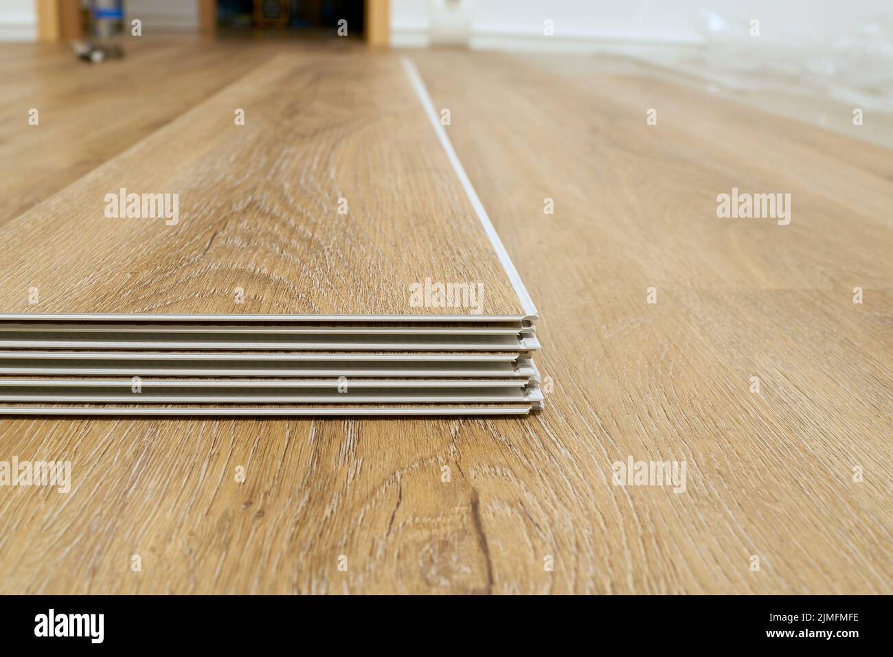 Klicken Sie auf Vinylboden, um sich im Wohnzimmer einer Wohnung zu installieren Stockfoto
