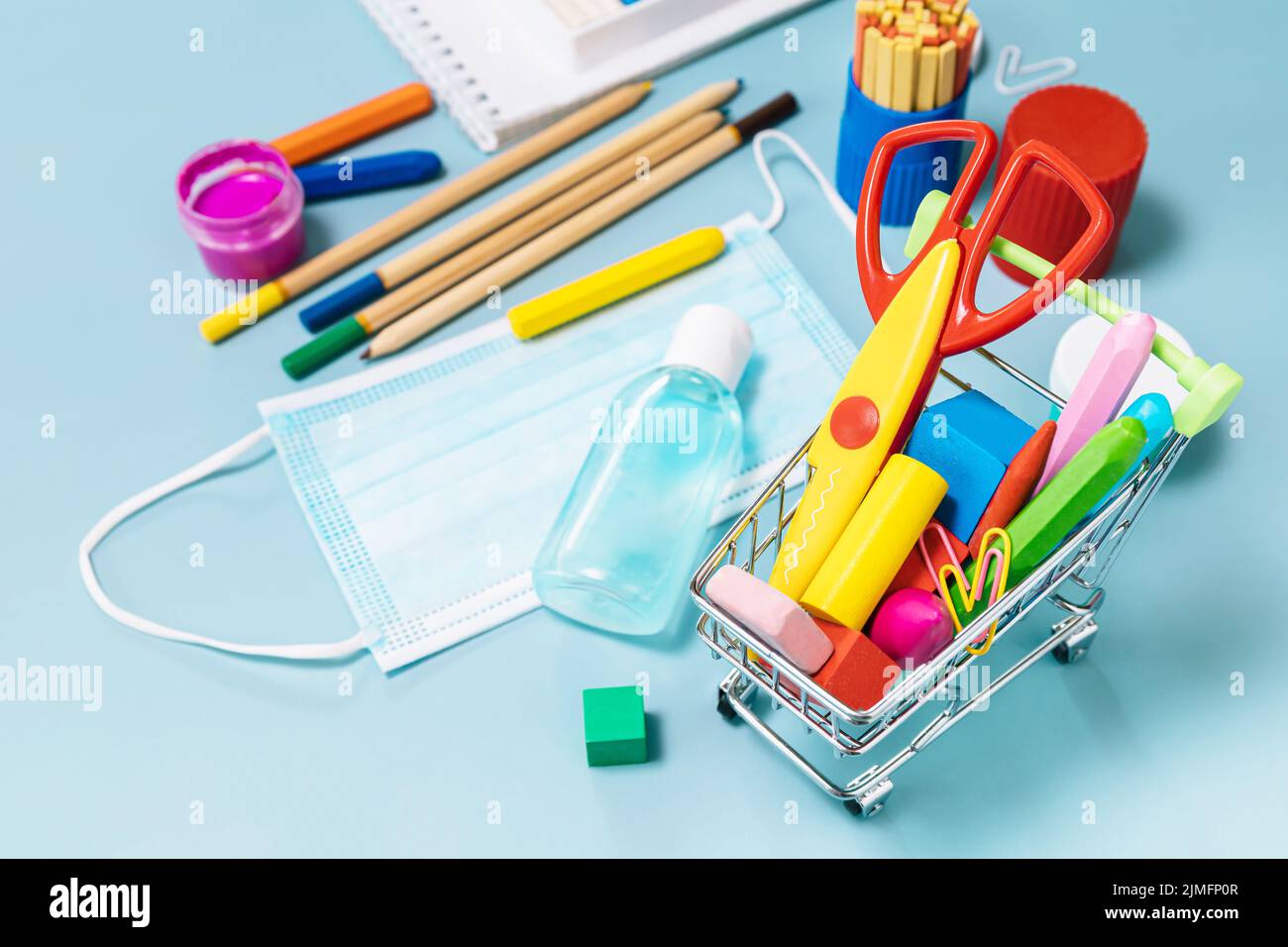 Schulbedarf, poppit Anti-Stress, Gesichtsmaske, Flasche Desinfektionsmittel, für den Rückweg in die Schule auf blauem Hintergrund. Covid-19 Vorsichtsmaßnahmen, gesund zu bleiben. Stockfoto