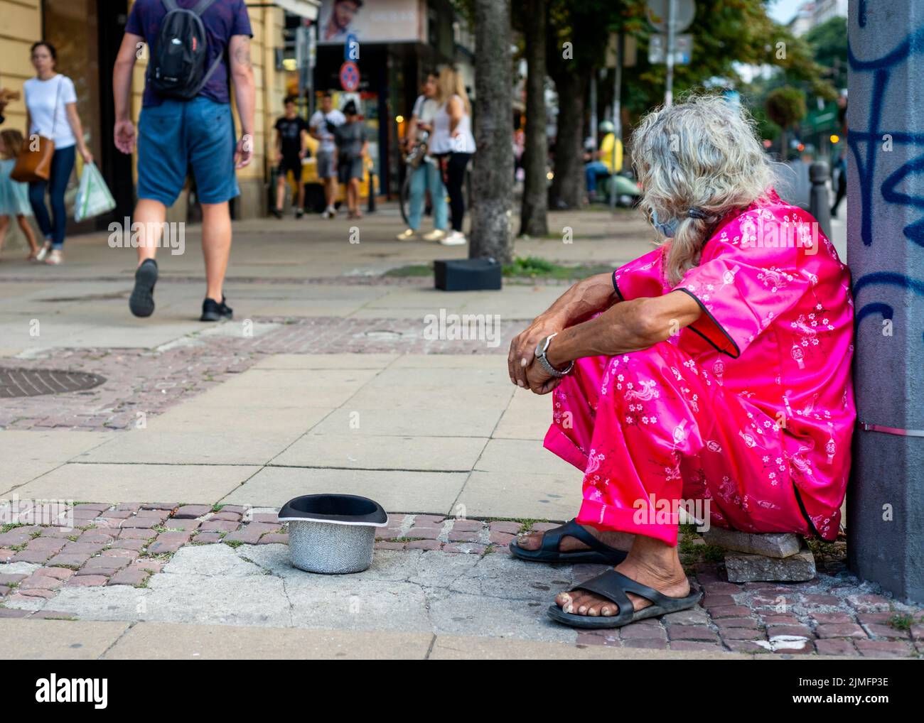 Männlicher Bettler in rosafarbener Kleidung, der auf den Straßen von Sofia, Bulgarien, Osteuropa, Balkan und der EU um Geld bettelt Stockfoto