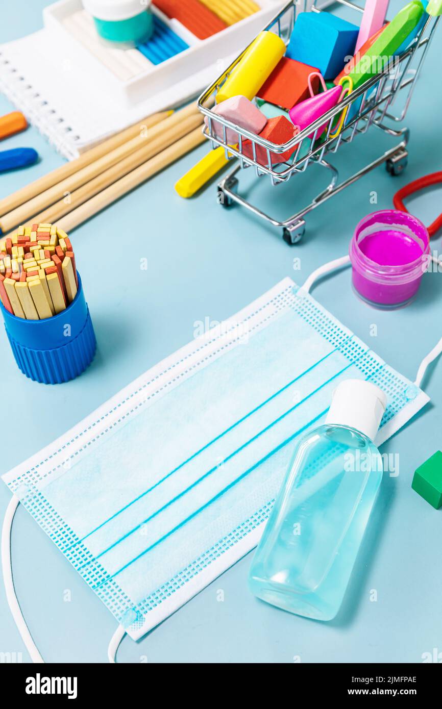 Schulbedarf, poppit Anti-Stress, Gesichtsmaske, Flasche Desinfektionsmittel, für den Rückweg in die Schule auf blauem Hintergrund. Covid-19 Vorsichtsmaßnahmen, gesund zu bleiben. Stockfoto