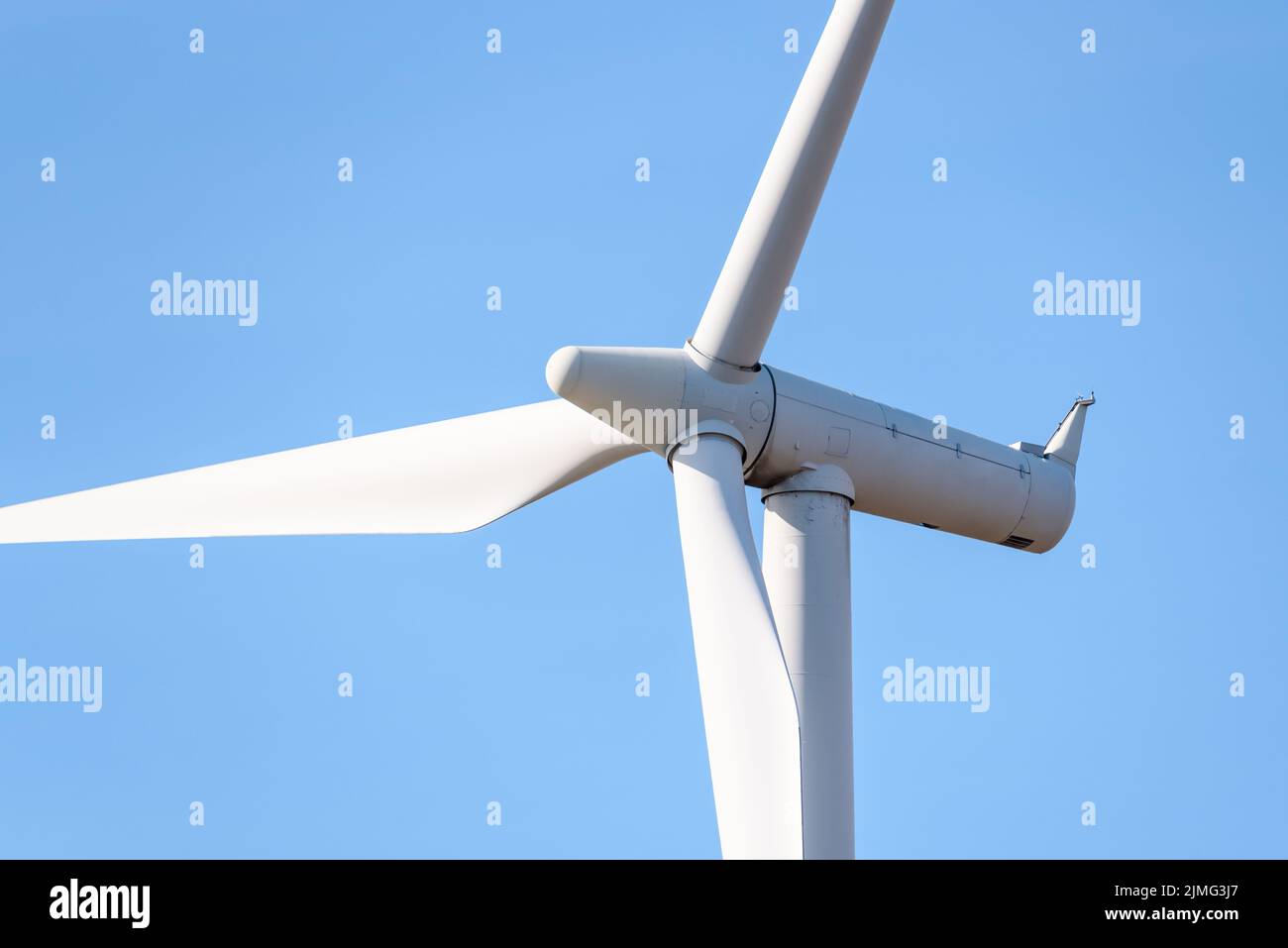Nahaufnahme einer Windkraftanlage, die im Herbst Strom gegen den blauen Himmel erzeugt Stockfoto