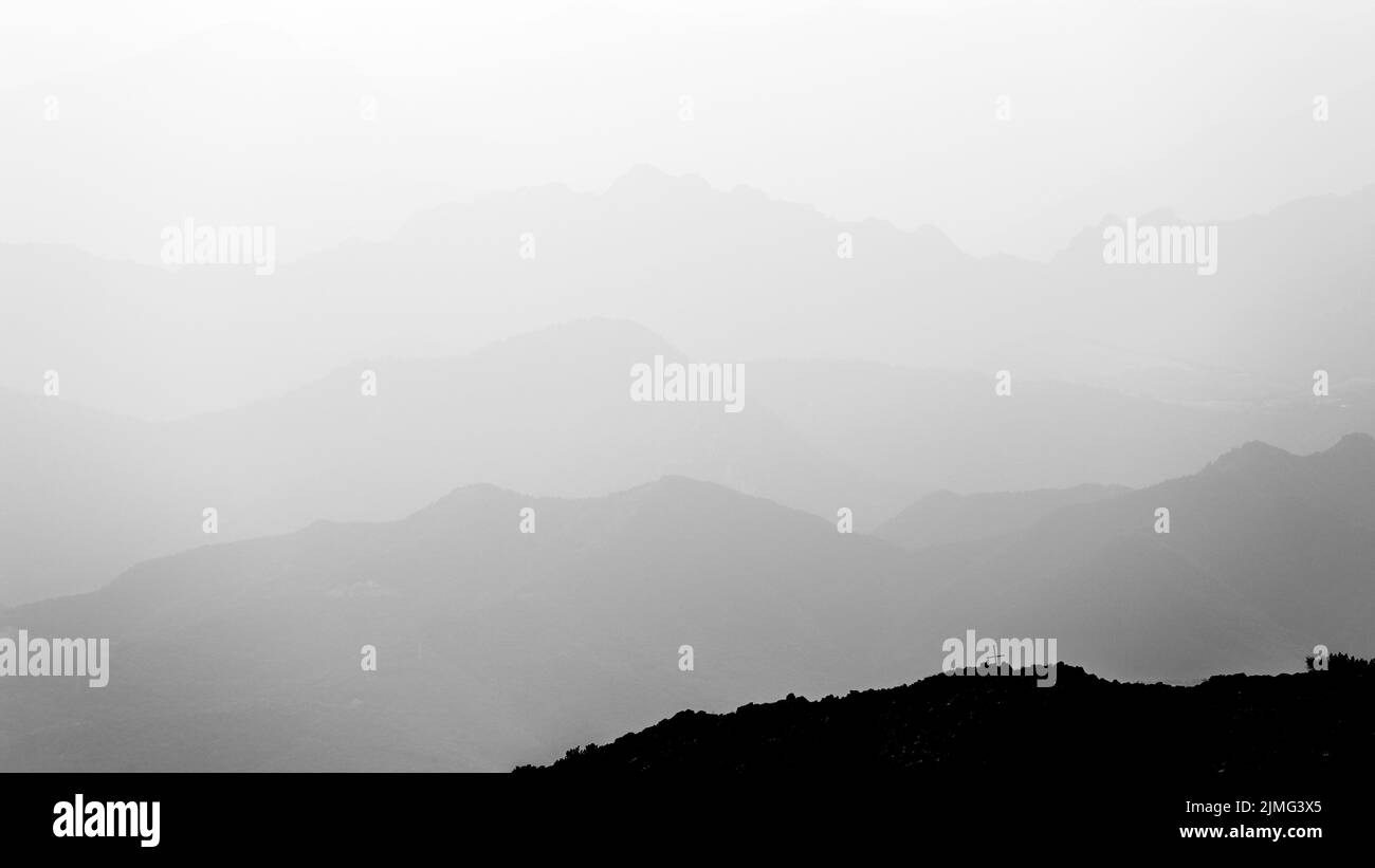 Bergschichten in schwarz und weiß. Querprofil. Atmosphäre mit Nebel, Wolken. Italien. Europa. Stockfoto