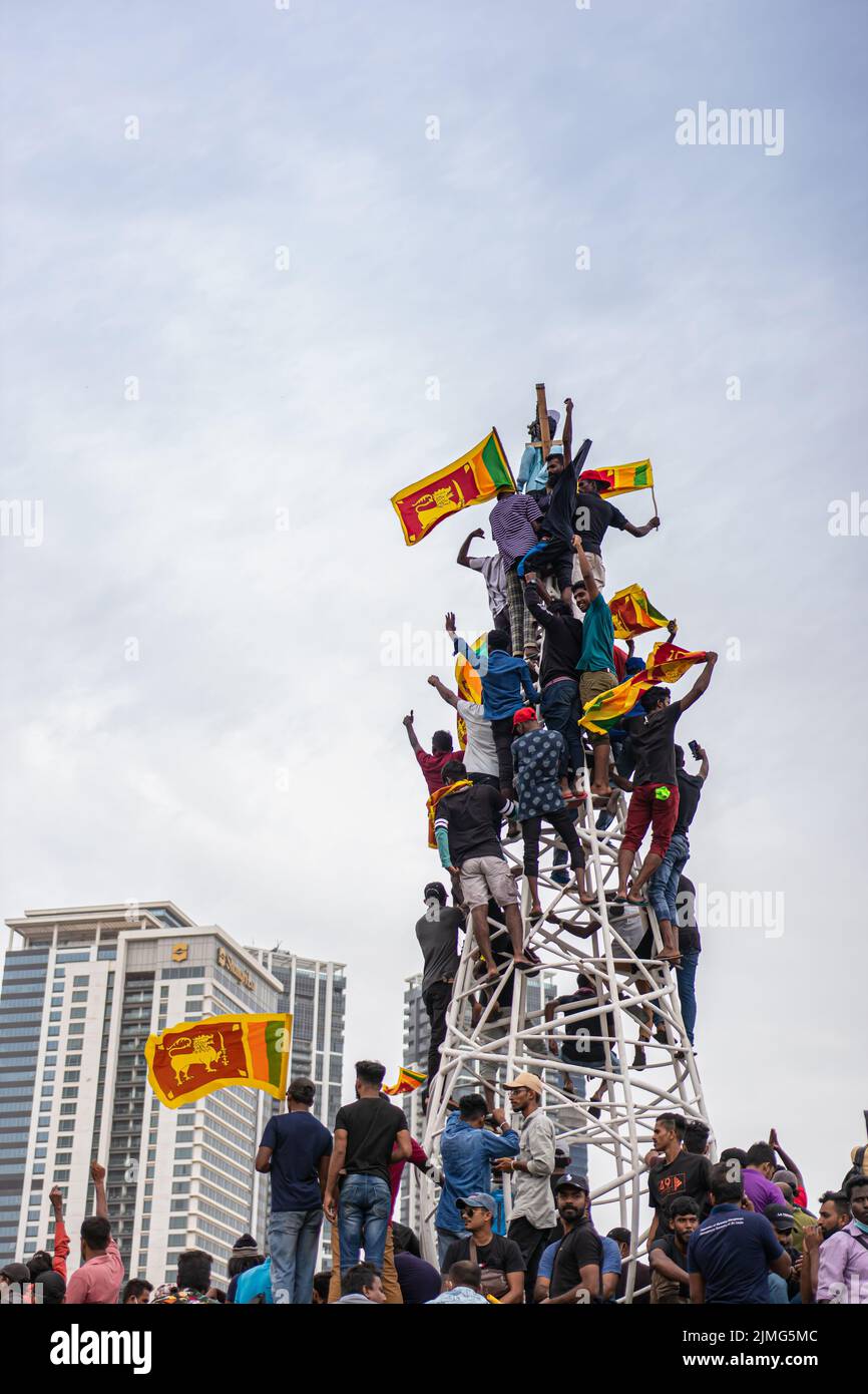 COLOMBO, SRI LANKA: 9.. Juli 2022: Jubelnde Demonstranten klettern auf einen Rahmen und hängen während regierungsfeindlicher Straßenproteste eine Figur des Präsidenten auf. Stockfoto
