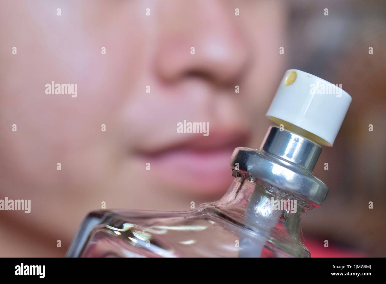 Südostasiatischer, chinesischer und myanmarischer junger Mann mit kalter Grippe bekommt Geruchverlust, genannt Anosmie. Er riecht nach Parfüm. Stockfoto