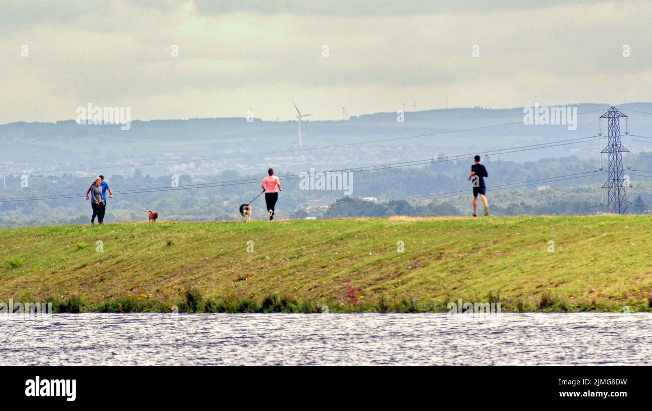 Milngavie, Glasgow, Schottland, Großbritannien 6.August 2022. Wetter in Großbritannien: Sunny sah Einheimische rund um den Stausee, der die Stadt versorgt und darüber thront, und in den Vororten ein hübsches kleines Stadtzentrum, das wie überall leidet. Credit Gerard Ferry/Alamy Live News Stockfoto