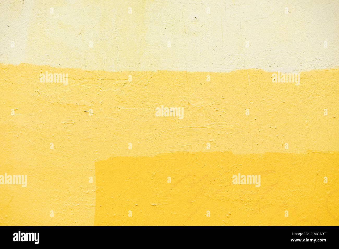 Textur ist gelbe Farbe. Kombination von gelben Farbtönen an der Wand. Oberfläche der lackierten Wand. Stockfoto