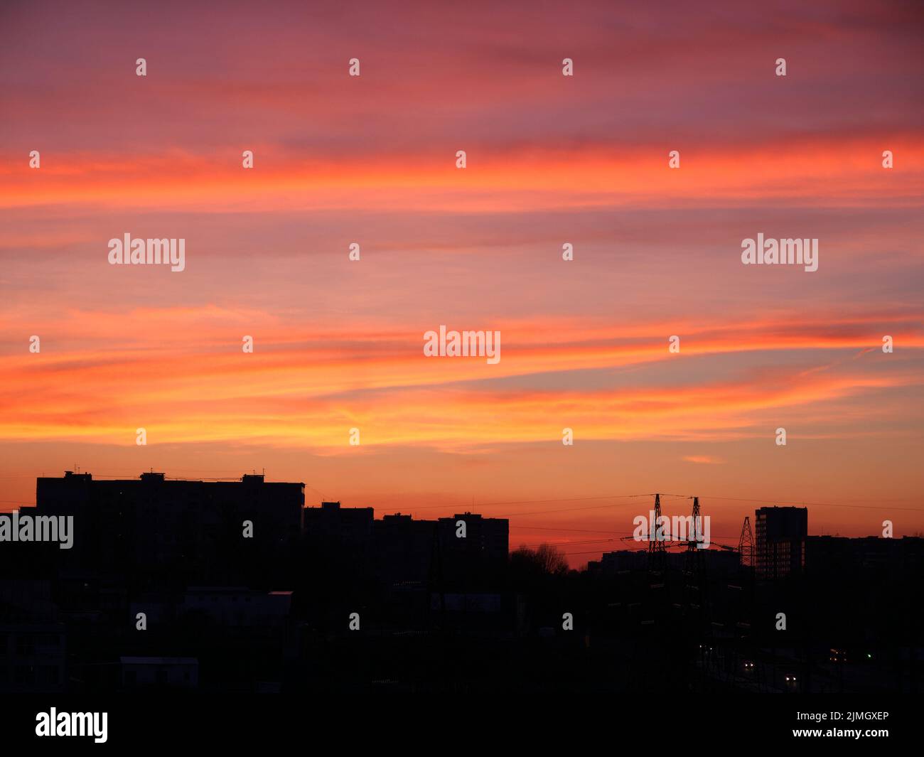 Strahlender Sonnenuntergang über der Silhouette der Abendstadt. Schöner, heller Sonnenuntergang über den Silhouetten des Gebäudes Stockfoto