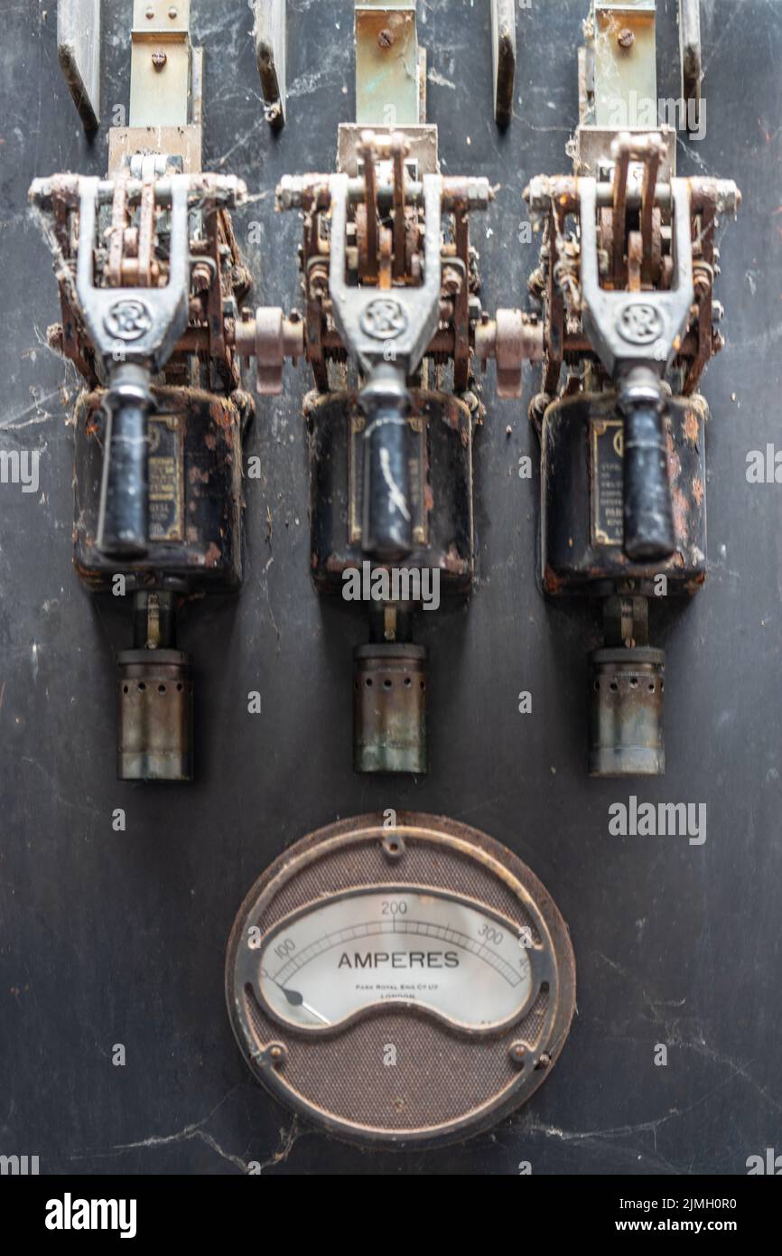 Alte, rostige Schalttafel und Strommessgerät in einer verlassenen Fabrik. Stockfoto