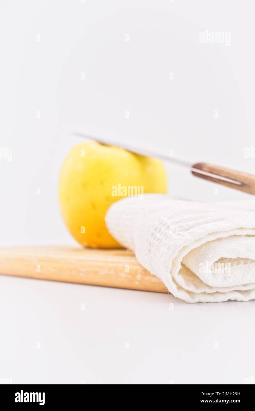 Frischer reifer Bio-Apfel und Messer auf einem hölzernen Schneidebrett mit Küchentuch Stockfoto