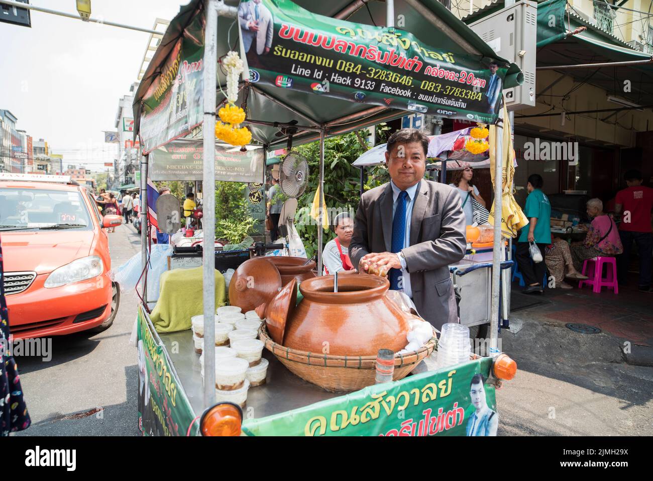 Die Straßen von Bangkok. Traditioneller Straßenverkäufer und farbenfrohe Taxis für den Transport Stockfoto