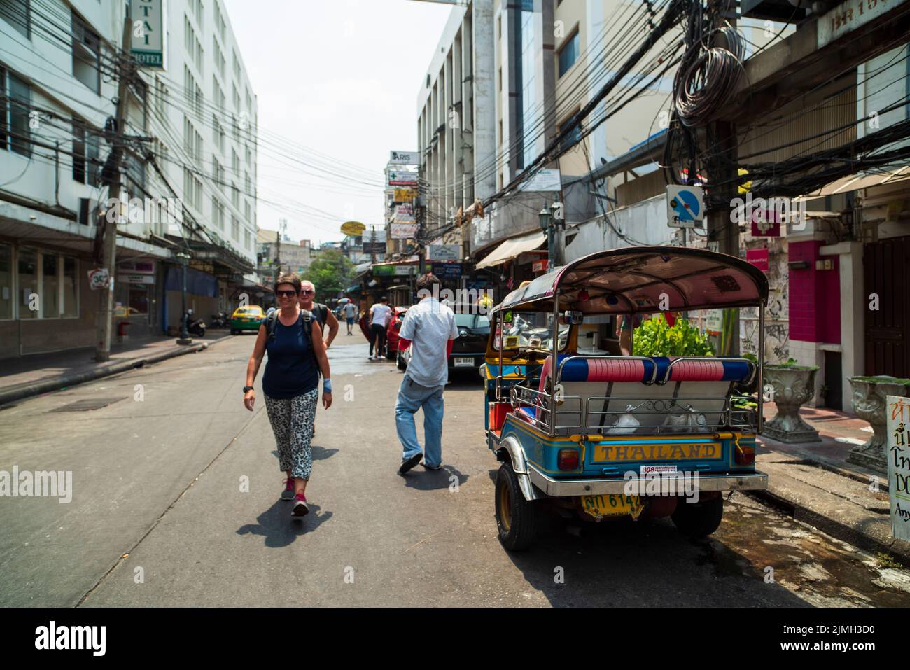BANGKOK - THAILAND, 20. März 2016. Die Straßen von Bangkok. Traditionelle Tuk Tuk Taxi und Straßenfahrt von ausländischen Touristen. Stockfoto