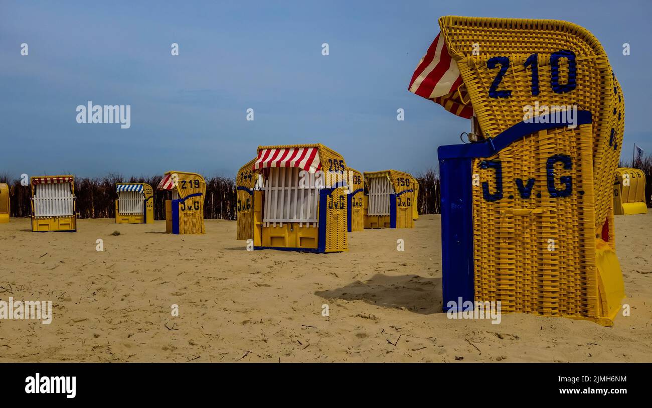 Mehrere Strandkörbe am Sandstrand der Nordsee in Cuxhaven, Deutschland Stockfoto
