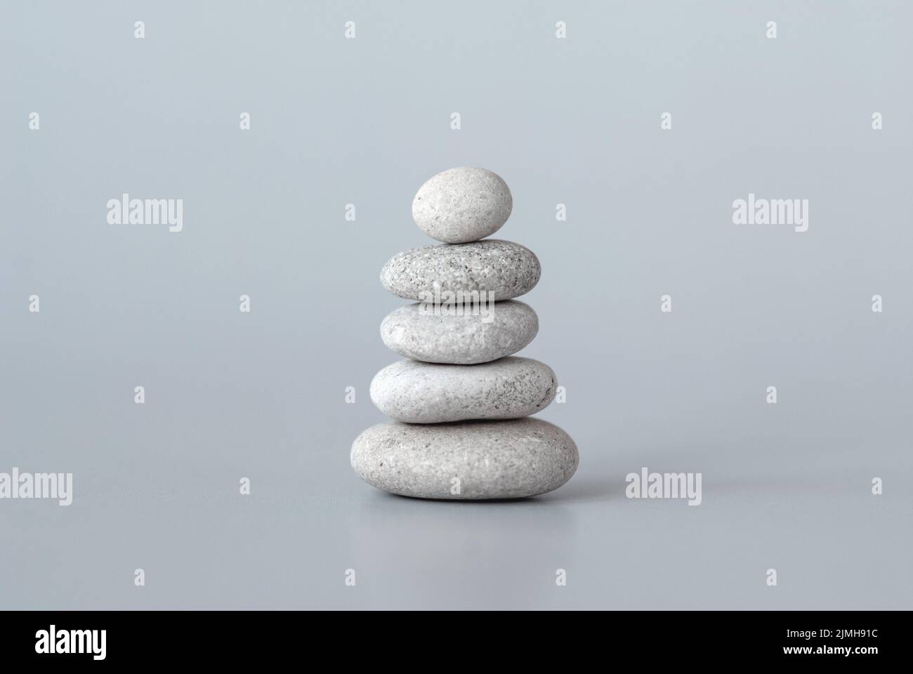 Kieselsteine stapeln sich auf grauem Hintergrund, Zen Balance Meditation minimales Konzept Stockfoto