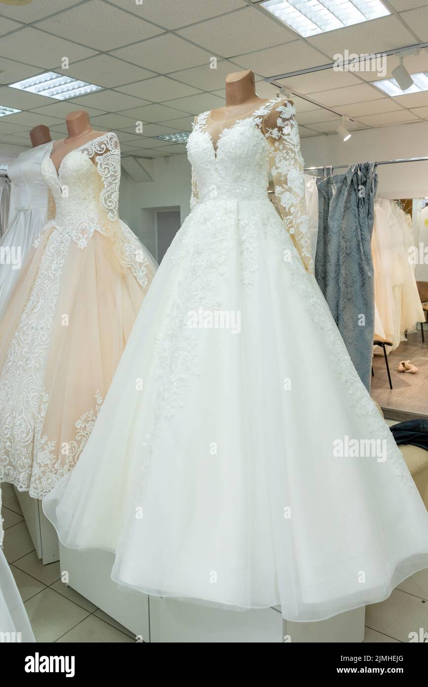 Schöne Hochzeitskleider in einer Brautboutique auf Schaufensterpuppen. Stockfoto