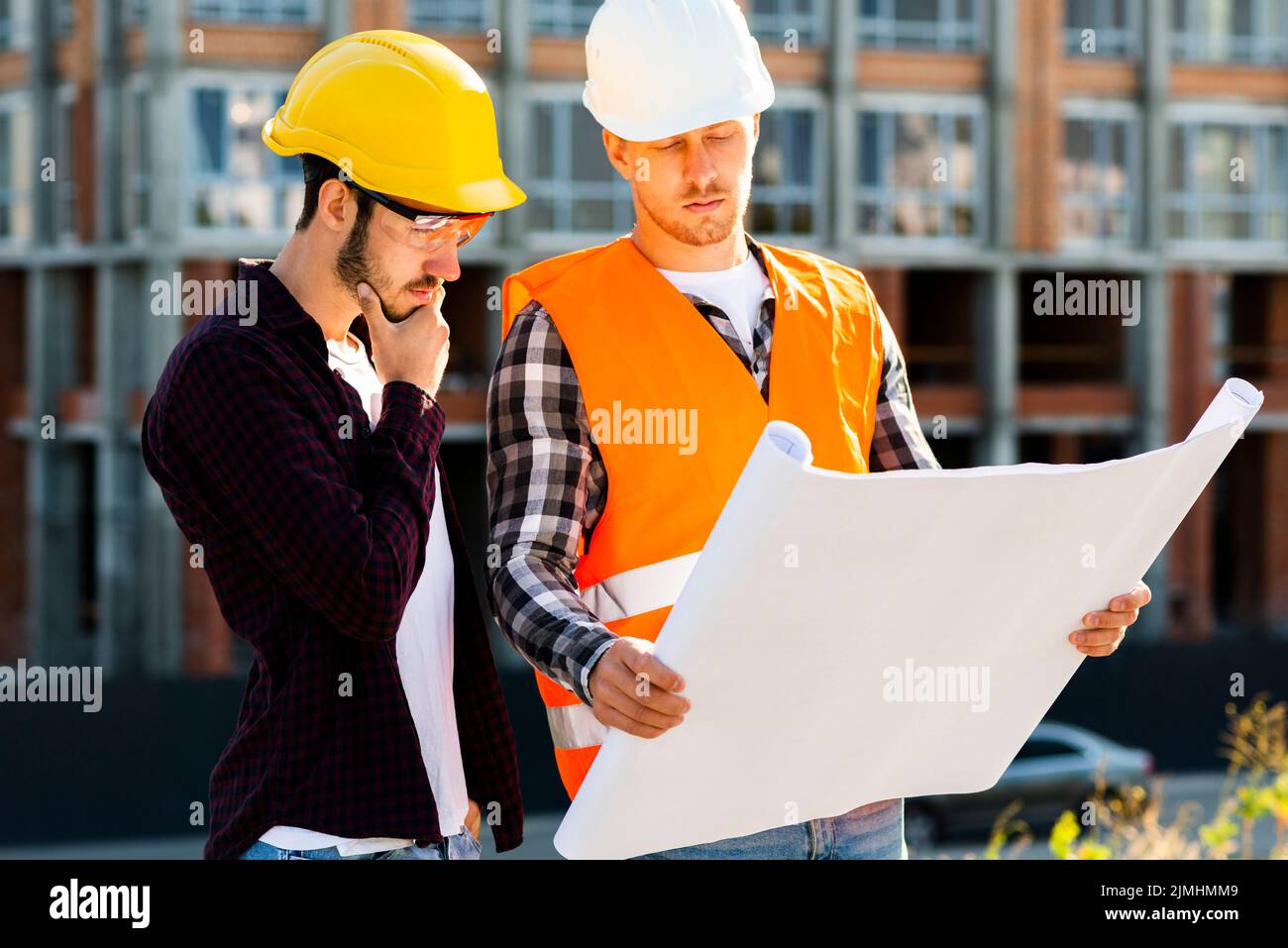 Mittlere Aufnahme Architekten Ingenieur suchen Pläne Stockfoto