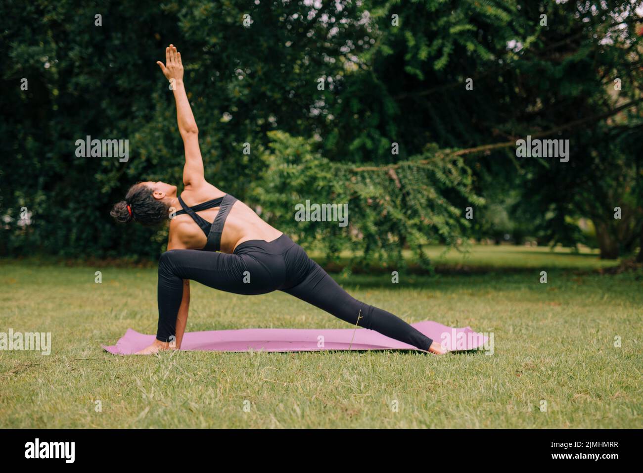 Junge Yogi Attraktive Frau, die Yoga-Garten praktiziert Stockfoto