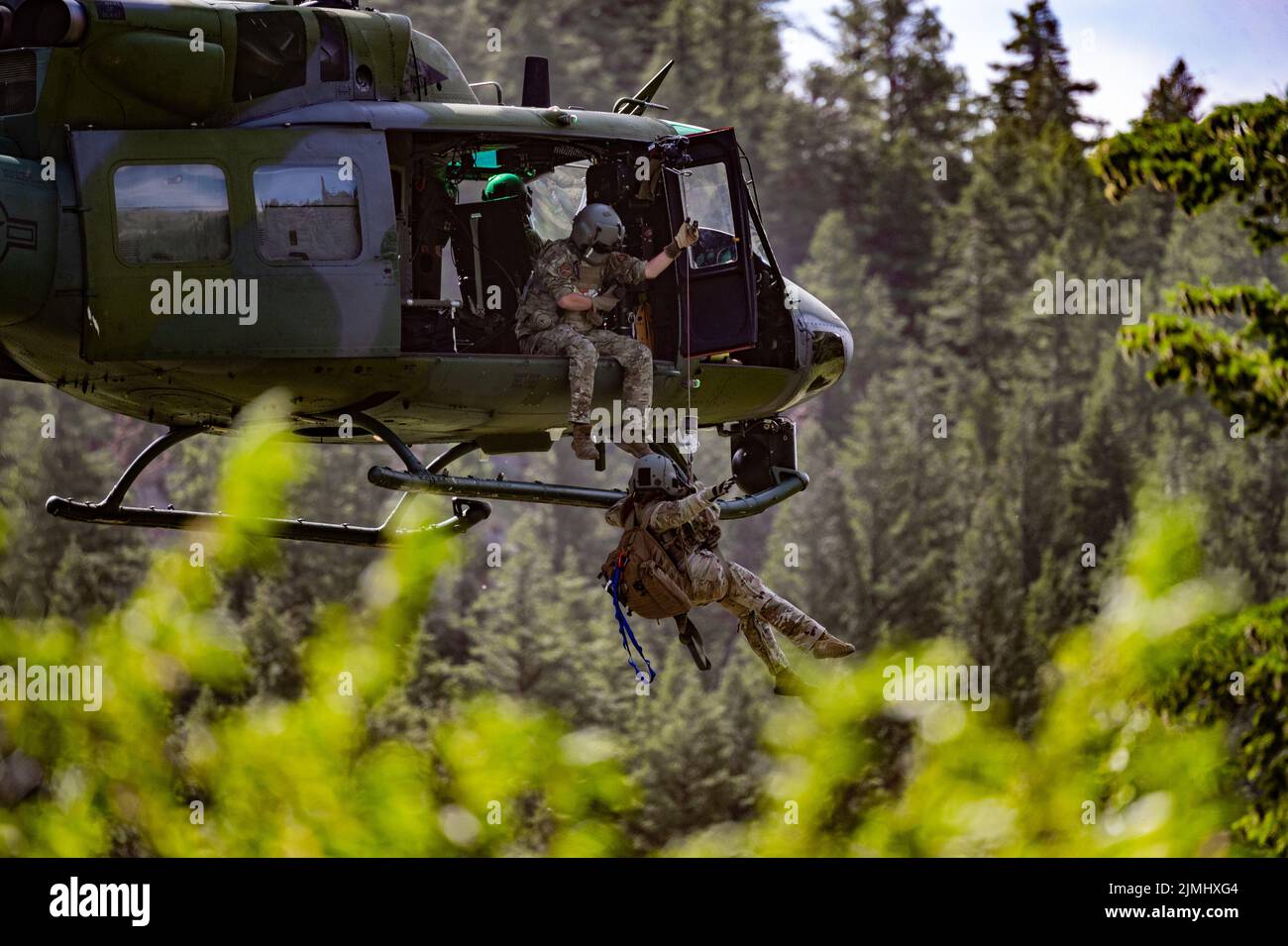 Technik. Sgt. Alex Landers, Flugingenieur des Hubschraubergeschwaders 40., senkt Maj. Joyanne Tesei, Flugärztin der medizinischen Gruppe von 341., aus einem UH-N1 Huey während einer Such- und Rettungsübung am 3. August 2022 im Sluice Boxes State Park. Ziel der Übung war es, SAR-Missionen und Hebeoperationen unter Anleitung von Bodeneinheiten zu üben. (USA Luftwaffe Foto von Airman 1. Klasse Mary Bowers) Stockfoto