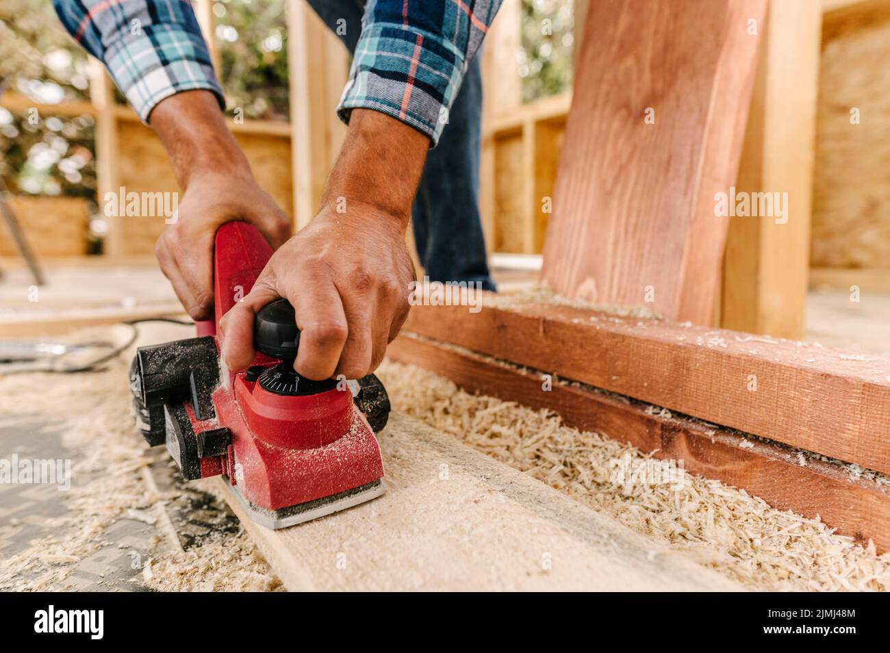Bauarbeiter schleift Holzstücke ab Stockfoto