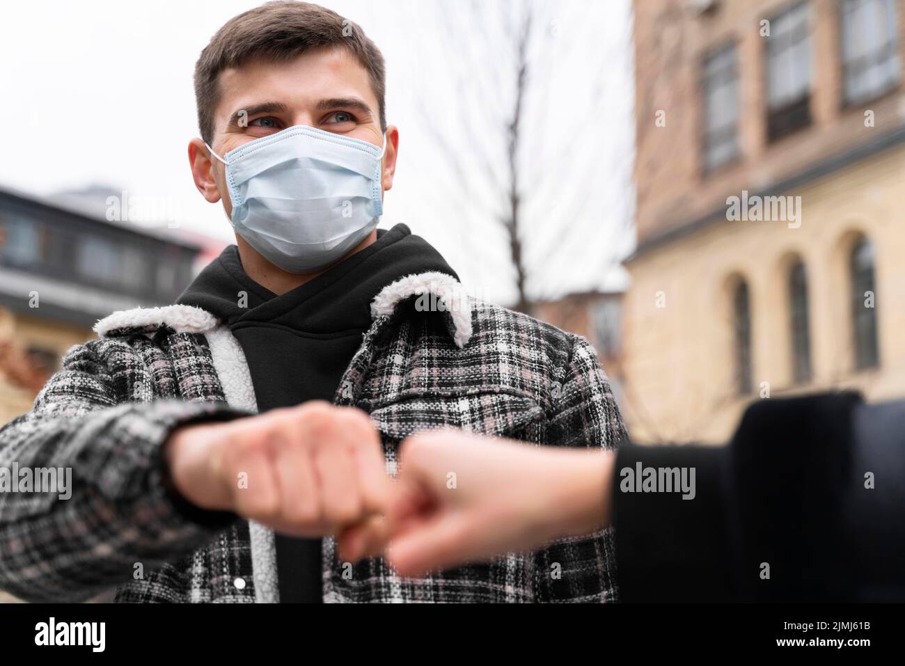 Alternative Grüße fast berühren Faust Beulen Mann mit Maske Stockfoto