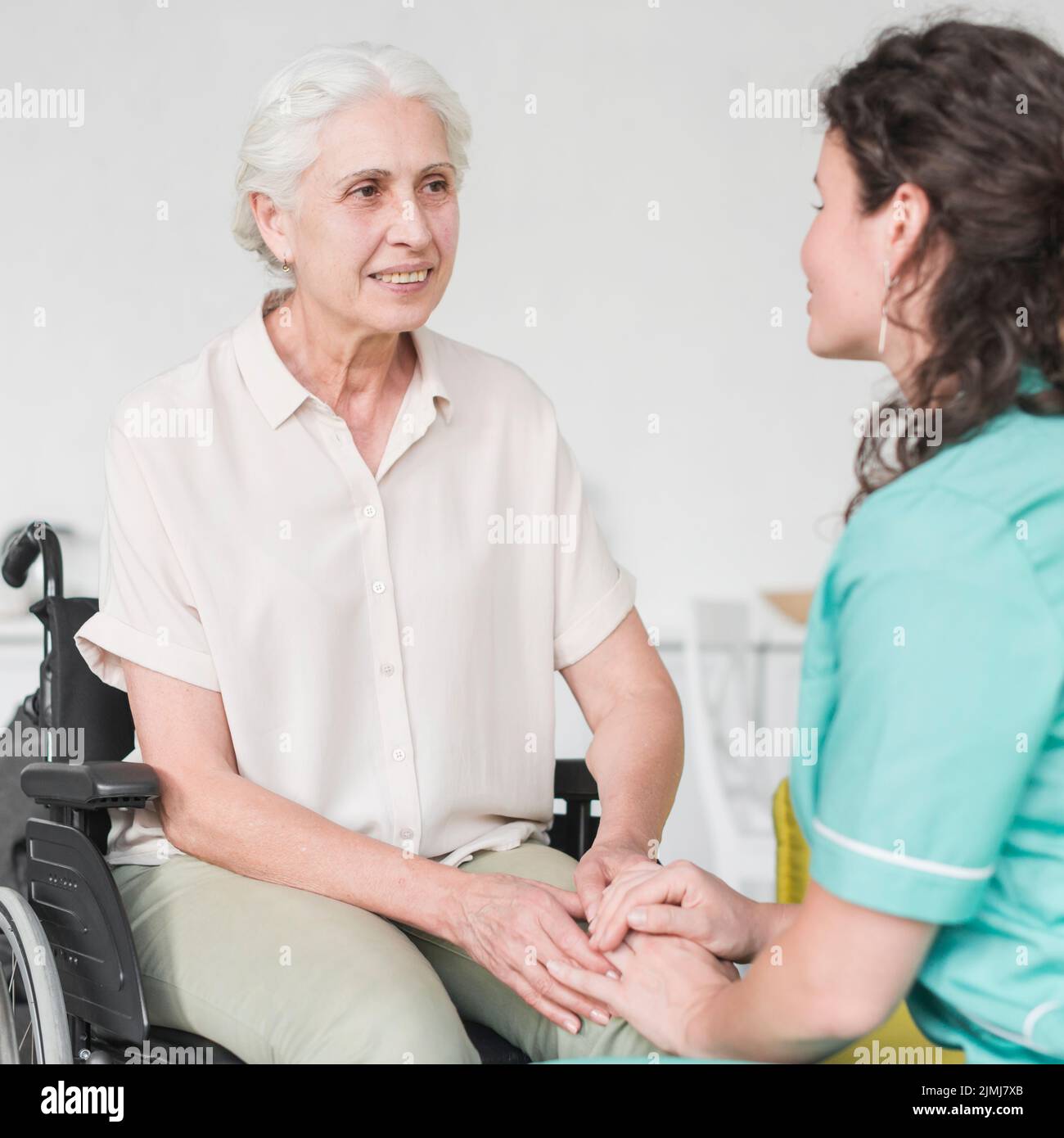 Glückliche behinderte Krankenschwester sitzen Rollstuhl suchen Hausmeister Stockfoto