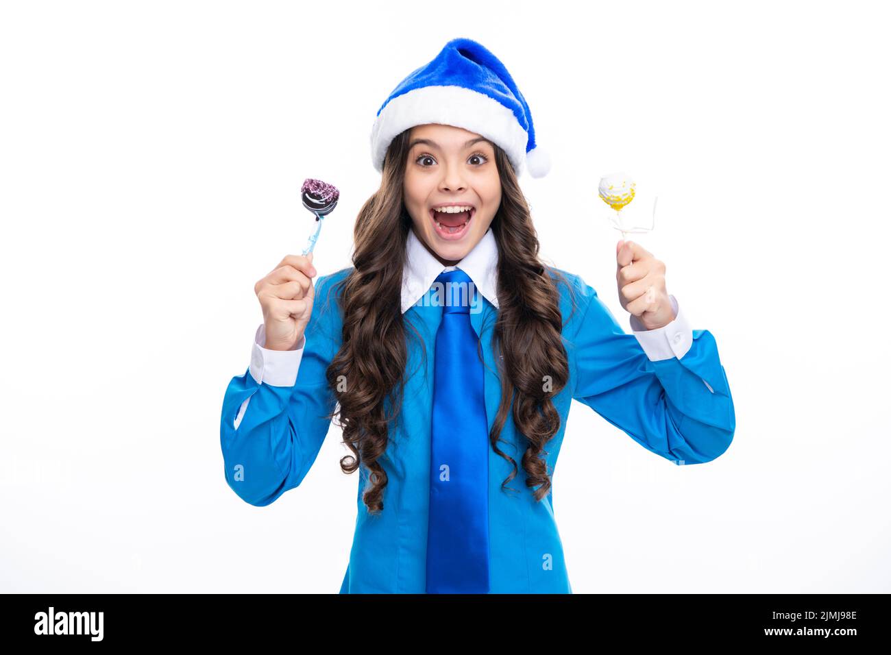 Aufgeregt Kind halten weihnachten Süßigkeiten Lollipop. Teenager-Mädchen auf weihnachten Neujahr isoliert in weißen Studio Hintergrund. Teenager Kind in santa Hut. Blau Stockfoto