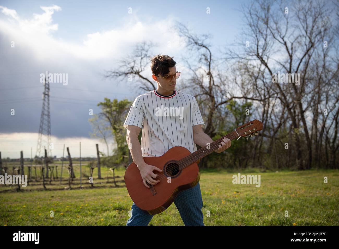 Ein Musiker spielt klassische Gitarre, wenn er draußen an der frischen Luft ist Stockfoto