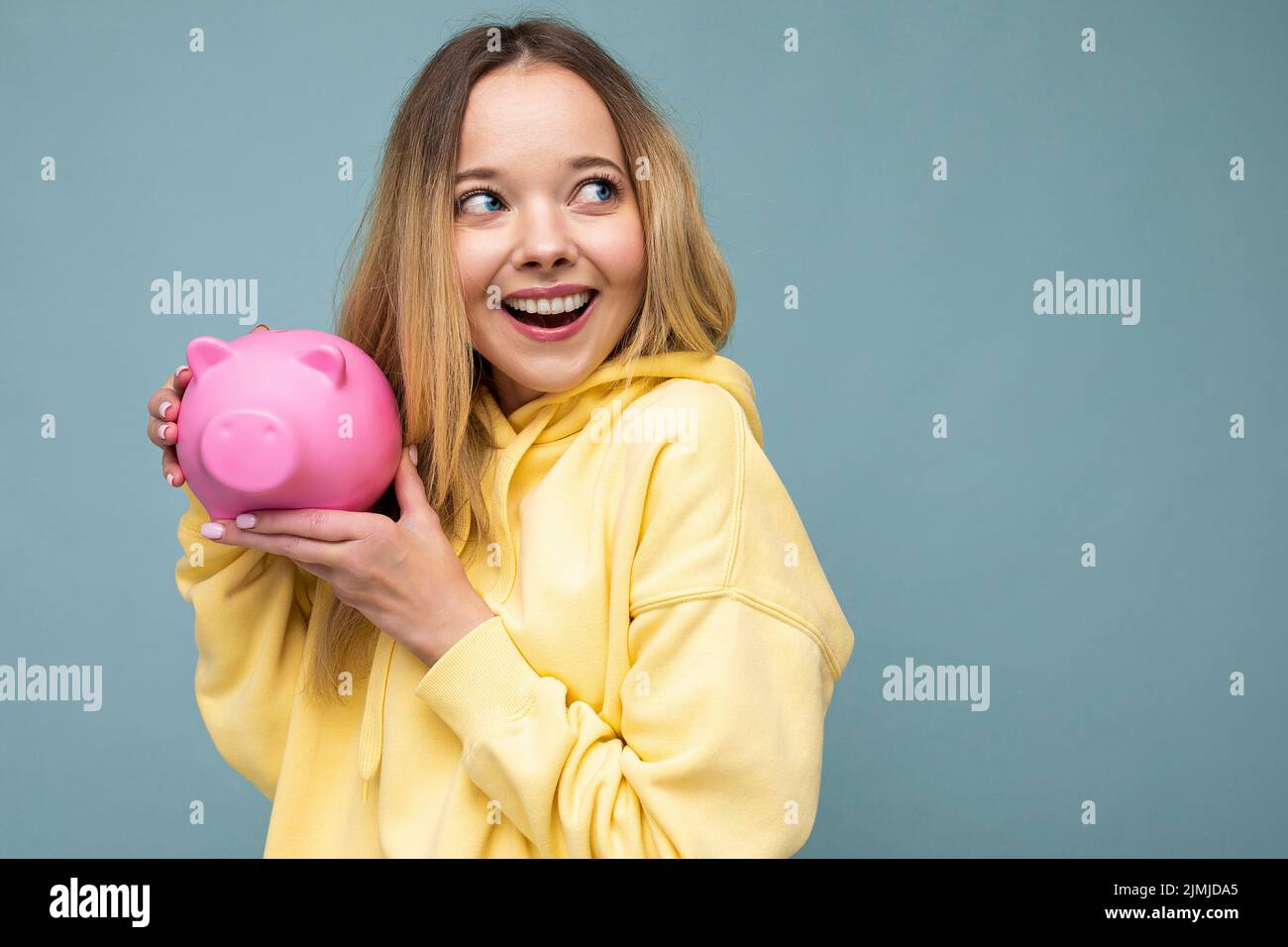 Portrait Foto von glücklich positiv lächelnd junge schöne attraktive blonde Frau mit aufrichtigen Emotionen tragen trendigen gelben Hoo Stockfoto